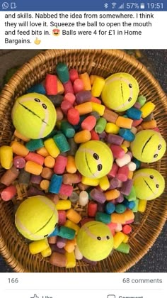 a basket filled with lots of different colored candies next to two tennis balls on top of each other