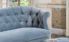 a blue couch sitting in front of a window