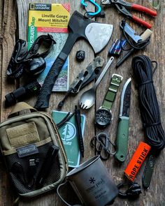 the contents of an outdoor survival kit laid out on a wooden table with tools and other items