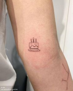 a small birthday cake tattoo on the arm