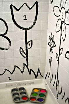 the bathroom is decorated in black and white with flowers on the wall next to the bathtub