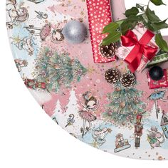 a table topped with lots of wrapping and christmas presents next to a potted plant