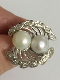 Details: A Unique and one of a kind Ring Handmade Vintage Ring Custom Made Ring (Estimated Late 1960's Early 1970's) 14Karat White Gold Ring Shank is nice and wide 2 Cultured Pearls in the Center One Pearl color is White the other has a silver tone color There are 12 diamond Stones around the Crown Estimate Total Weight .25ct Ring weight : 7.3 Grams Ring is appraised for the value of $2750 Since the following ring is Vintage no changes will be made to the ring Ring will be shipped via FEDEX seco Elegant White Multi-stone Diamond Ring, Classic White Multi-stone Cluster Ring, Collectible Round White Gold Diamond Ring, Art Deco White Gold Rings Stamped 14k, White Gold Art Deco Rings Stamped 14k, Vintage White Gold Multi-stone Ring, Art Deco Multi-stone Ring For Formal Occasions, White Pearl Ring With 17 Jewels For Formal Occasions, White Bypass Ring With Prong Setting As Gift