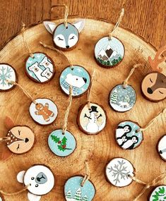 christmas ornaments are hanging on a wooden platter with twine string and tags in the shape of animals