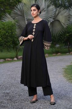 Black cotton kurta with gold floral, zari and mirror hand embroidered placket and sleeve hems. Comes with pant.
Components: 2
Pattern: Hand embroidered
Type Of Work: Floral, Zari, Mirror
Neckline: Boat Neck
Sleeve Type: Full
Fabric: Cotton
Color: Black
Other Details: 
Length:
Kurta: 46 inches
Pant: 40 inches
Occasion: Sangeet - Aza Fashions Boat Neck Kurta, Cotton Kurta, Gold Floral, Pant Set, Set For Women, Aza Fashion, Boat Neck, Fabric Cotton, Sleeve Type