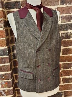 A uniquely designed, mens double breasted brown and deep red tweed waistcoat with a mock-suede collar.  Item is beautifully designed with Burgundy suede edging on the pockets and collar, and can be closed via three buttons on the front of the waistcoat.  This waistcoat as you can see has a unique back with a paisley design also in a deep red burgundy colour. The waistcoat can be adjusted with a button system adjustment also shown. This is ideal for a wedding or casual wear, great with a suit or a pair of jeans. Please see our online etsy shop to view our range of Tweed products for that perfect winter look. Brown Double-breasted Tweed Jacket For Tailoring, Fitted Single-breasted Tweed Vest, Brown Semi-formal Vest With Notch Lapel, Brown Notch Lapel Vest For Semi-formal Occasions, Semi-formal Brown Winter Vest, Fitted Brown Double-breasted Tweed Jacket, Fitted Double-breasted Brown Tweed Jacket, Brown Fitted Double-breasted Tweed Jacket, Tailored Brown Vest With Buttons