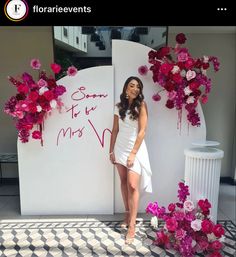 a woman standing in front of a flower display