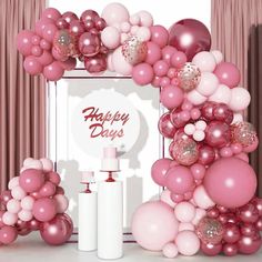 pink and white balloons are on display in front of a photo frame with the words happy day