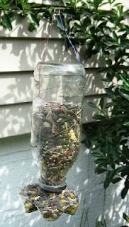 a bird feeder hanging from the side of a house