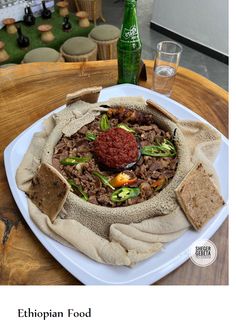 a white plate topped with food next to a green bottle