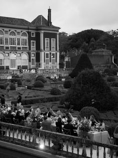 a group of people sitting at tables in front of a large building