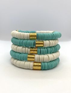 "This listing is for 1 White and Robin's Egg Blue \"Halfsies\" Bracelet. Each bracelet is hand-beaded with African clay discs and accented with a brushed gold cylinder bead. The bracelet is made with stretch elastic which makes it comfortable and easy to wear. My bracelets are made to fit an average wrist size of 6.5\"-7\". Take a look around my shop for additional colors to add to your stack! The more the better!" Adjustable Stacked Blue Bracelets, Adjustable Blue Stackable Stretch Bracelet, Blue Adjustable Stackable Stretch Bracelet, Blue Stacked Beaded Bracelets, Blue Stacked Bracelets With Round Beads, Blue Stackable Heishi Beads Bracelets, Blue Stacked Bracelets For Gift, Blue Stacked Bracelets As Gift, Blue Stacked Bracelets Gift