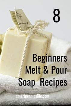 a soap bar sitting on top of a white towel next to a pile of towels