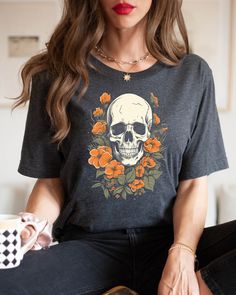 "We think this Whimsigoth style shirt is awesome! check out the skull and floral design, perfect for Halloween, drinking a coffee by the fireplace. We believe in comfort and quality. Our unisex T-shirts are super soft, ultra-comfy, and made with premium materials that feel as good as they look. ABOUT THE SHIRT 💙Our T-shirts are sourced from BELLA+CANVAS! FABRIC 👕Solid Colors: 100% Ringspun Cotton 👕Heather Colors: Soft cotton-poly blend (52% cotton, 48% polyester) SIZE AND FIT ✌🏼This style is Gothic Skull Print T-shirt For Fall, Gothic Short Sleeve T-shirt With Skull Print, Relaxed Fit T-shirt For Halloween Alternative Fashion, Skull Print Crew Neck Top For Alternative Fashion, Casual Tops With Skull Shape For Alternative Fashion, Day Of The Dead Skull Print Short Sleeve T-shirt, Halloween Skull Cotton Shirt, Day Of The Dead Skull Print Short Sleeve Tops, Gothic Skull Print T-shirt For Halloween