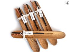 five wooden spoons with labels on them are lined up against a white background and tied together