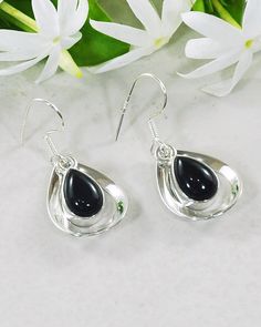 Immerse yourself in the graceful swaying hues of these beautiful statement earrings. Our authentic Black Onyx Earrings- Aura Drops are the epitome of elegance. Pretty teardrop gemstones are lovingly embraced within a sterling silver frame for a subtle, wholesome look. These earrings will add a playful refinement to any outfit, whether it's your blouse and work pants or leather jacket and jeans ensembles. Authentic Sivalya Black Onyx Black Onyx: Endurance, Perseverance, Grounding Hallmarked Metal Black Teardrop Gemstone Earrings, Black Teardrop Sterling Silver Earrings, Black Teardrop Earrings For Formal Occasions, Silver Onyx Teardrop Earrings, Black Sterling Silver Teardrop Dangle Earrings, Black Sterling Silver Teardrop Earrings, Elegant Black Teardrop Earrings In Sterling Silver, Elegant Black Teardrop Sterling Silver Earrings, Elegant Black Sterling Silver Teardrop Earrings