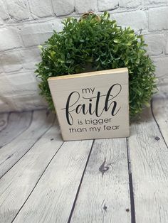 a wooden sign that says, my faith is bigger than my year on the front