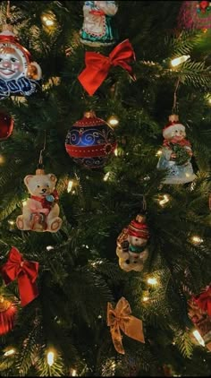 a christmas tree with ornaments and lights on it's branches, including teddy bears