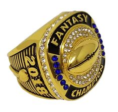 a gold and black ring with the words fantasy on it, surrounded by blue crystals