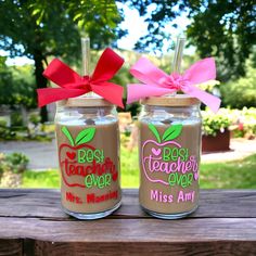 two mason jars with teacher's day decorations on them, one has a pink ribbon and the other has an apple