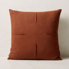 a brown pillow on a white surface