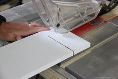 a person using a machine to cut paper