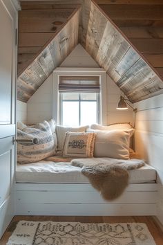 a window seat in the corner of a room with pillows and rugs on it