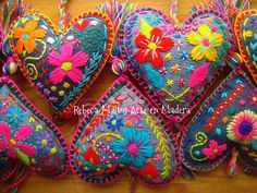 colorful embroidered heart ornaments hanging on a wall