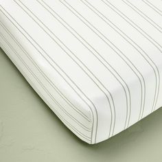 a close up view of a mattress with white and green stripes on the coverlet