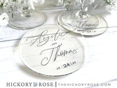 two personalized wine glasses sitting on top of a table with flowers in the background