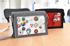 two purses sitting on top of a wooden table next to each other with different types of buttons