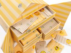 an open box with yellow and white designs on it's lid, sitting next to other boxes