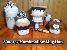 there are crocheted hats on top of mugs with marshmallow toppings