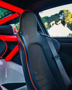 the interior of a sports car with orange stitching