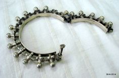 "VINTAGE ANTIQUE GREAT DESIGN TRIBAL OLD SILVER HINGE BRACELET BANGLE (KAKAN) FROM RAJASTHAN INDIA. Silver guard bangles (Khatria or bangri gokru) with hollow balls perimeters. Worn by DANGEE and PATEL tribal people of Rajasthan. One quarter-hinged part can be opened by central pin. Piece is good worn with a great antique look. See similar samples in\" Traditional jewelry of India\" by Oppi Untractht. Inner diameter - 6.3 cm(2.5\") Outer diameter - 10 cm(3.9\") Inner circumference - 19.8 cm(7.8\ Luxury Traditional Antique Silver Bracelet, Traditional Antique Silver Bangle For Festivals, Traditional Antique Finish Bangle Jewelry, Antique Oxidized Bangle For Festivals, Antique Oxidized Bangle For Wedding, Antique Silver Bangle For Festive Occasions, Traditional Heavy Antique Silver Bangle, Antique Silver Bangle For Festivals, Vintage Bangle For Rituals And Festivals