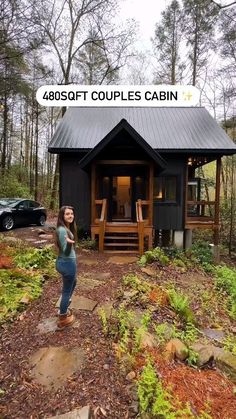 a woman standing in front of a small cabin