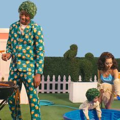 two women and a man in matching outfits are standing near a bbq with children on it