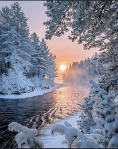 the sun is setting over a river surrounded by snow covered trees