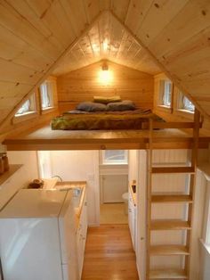 a loft bed is built into the side of a small cabin with stairs leading up to it