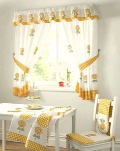 a table and chairs in front of a window with sunflowers on the curtains