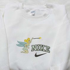 Introducing the magical collaboration between Nike and Tinkerbell! Our Nike x Tinkerbell Cartoon Embroidered Sweatshirt combines the enchanting world of Disney with the iconic style of Nike. Featuring a beautifully embroidered Tinkerbell cartoon on the front, this sweatshirt is a must-have for any Disney lover. The premium quality fabric ensures comfort and durability, while the relaxed fit adds a trendy touch to your wardrobe. Whether you’re heading to the gym or hanging out with friends, Disney Crew Neck Sweatshirt With Embroidered Logo, Disney Cotton Sweatshirt With Embroidered Graphics, Disney Embroidered Long Sleeve Sweatshirt, Disney Style Cotton Hoodie For Disney Fan Events, White Disney Crew Neck Sweatshirt, White Disney Cotton Sweatshirt, Tinkerbell Cartoon, Nike Cartoon, Best Birthday Gift Ideas