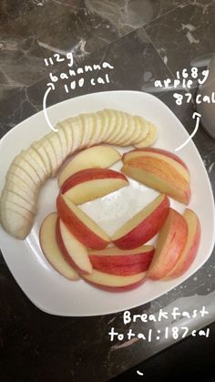 a white plate topped with sliced apples next to a banana and apple slice on top of it