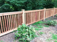 a wooden fence in front of some trees