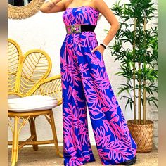 A Vibrant, Strapless Jumpsuit With A Pink Floral Pattern With A Royal Blue Undertone. Features A Flowy, Wide-Legged Design. This Simple Yet Stylish Jumpsuit Can Be Easily Transformed From Casual To Chic! This Is A Must-Have For This Season. Great For Casual Events And Even A Night Out! Belt Is Not Included. Multicolor Print Strapless Jumpsuit Without Belt Neckline: Strapless Sleeve: None Fabric: Polyester/Spandex (Fabric Has Stretch) Length: Full Season: Spring, Fall, Summer Made In: Turkey Size Pink Strapless Jumpsuits And Rompers For Party, Blue High Waist Strapless Jumpsuit For Summer, Pink Strapless Jumpsuit For Summer Party, Pink Fitted Strapless Jumpsuit For Summer, Purple Beach Jumpsuits And Rompers, Chic Purple Beach Jumpsuits And Rompers, Chic Pink Jumpsuits For Beach Season, Casual Pink Strapless Jumpsuit For The Beach, Pink Strapless Sleeveless Jumpsuit For Vacation