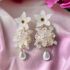 🌸 Introducing our charming Magnolia Flower Earrings, showcasing a simple and elegant white color that adds a touch of sophistication to any look. 🌸 Each earring is adorned with intricately beaded blooming flowers, exhibiting remarkable detail and a delightful aesthetic. 🌸 Crafted with hypoallergenic materials, these earrings provide a comfortable and safe wearing experience for all. 🌸 The lightweight design makes them suitable for both everyday wear and special formal occasions. 🌸 Perfect for various events, including weddings, parties, or simply adding a cute and elegant flair to your daily outfits. 🌸 Elevate your style effortlessly with these lightweight, easy-to-wear, and beautifully detailed Magnolia Flower Earrings, adding a touch of elegance and charm to any occasion. ✈️ Handli Whimsical White Flower Shaped Earrings, Elegant Hypoallergenic Flower-shaped Earrings, Elegant White Flower-shaped Earrings, Magnolia Earrings, Flower-shaped Bridal Earrings With Flower Charm, White Magnolia Flower, Magnolia Jewelry, Jewelry Elegant, Anniversary Gift For Wife