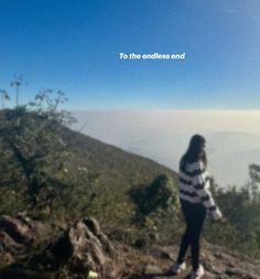 a woman standing on top of a mountain