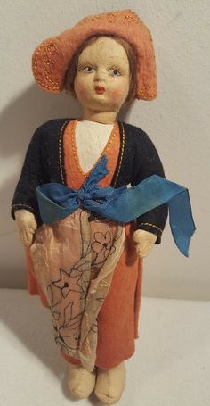 a small doll with a blue ribbon around its neck