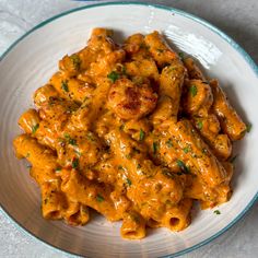 a white bowl filled with pasta covered in sauce and cheese on top of a table