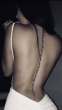 the back of a woman's body with tattoos on her upper and lower back