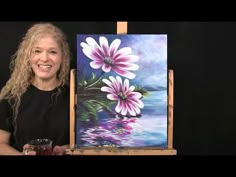 a woman holding a cup next to an easel with flowers on it and the words time lapse